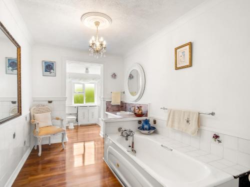 a white bathroom with a tub and a sink at Conamara House in Ballyconneely