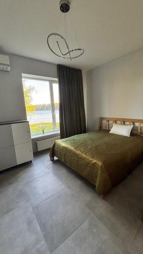 a bedroom with a bed and a large window at Orinoko Guest House in Stacija Sece