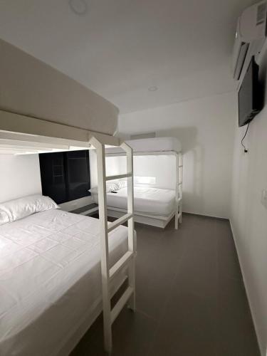 two bunk beds in a white room with a tv at Finca Exclusiva en Carmen de Apicalá in Carmen de Apicalá