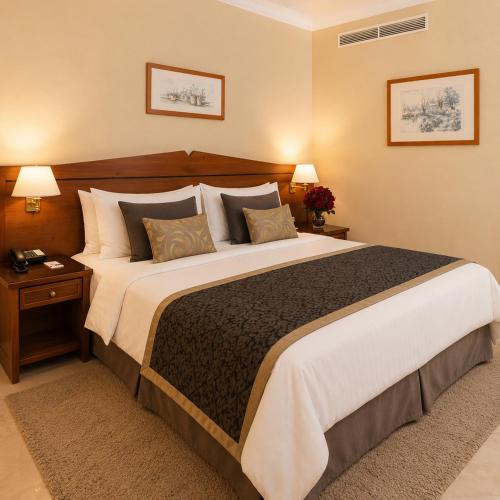 a large bed in a hotel room with two lamps at Golden Carthage Hotel & Residence Tunis in Gammarth