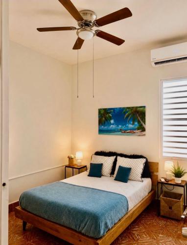 a bedroom with a bed with a ceiling fan at Villa Zoed in San Juan