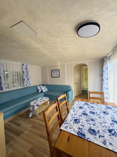 a living room with a blue couch and a table at Domki Dolce Vita in Jastarnia