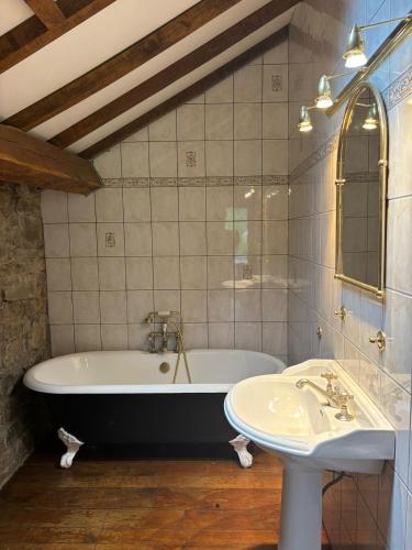 a bathroom with a bath tub and a sink at Maison Camille in Hotton