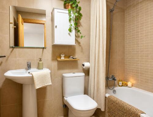 a bathroom with a toilet and a sink and a bath tub at Brisa del Mar - 2 min playa in El Ejido