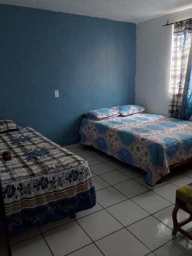 two beds in a room with blue walls at Family vacation, comfortable space in Zacatecas