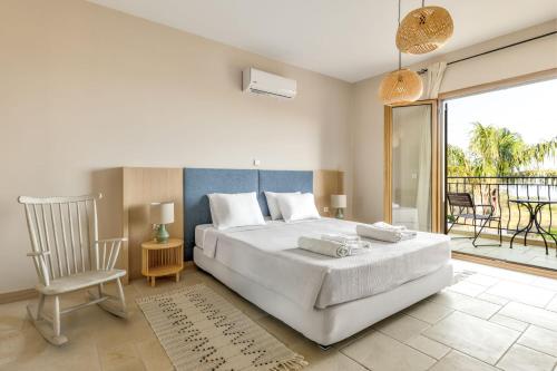 a bedroom with a large white bed and a balcony at Villa AmberBlue Kalathos in Kalathos