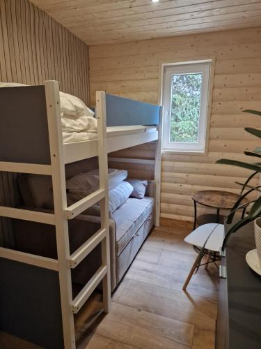 a room with bunk beds in a log cabin at Leśny Staw Stodoła in Gilwa