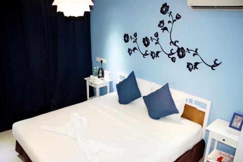 a bedroom with a white bed with blue walls at Boutique Hote123 in Kuala Lumpur