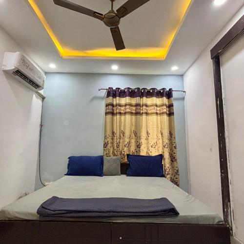 a bed in a room with a ceiling fan at GoBravo 48 - 2BHK Farm with Pool and Garden Sector 150 Noida in Greater Noida