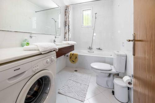 a white bathroom with a washing machine in it at Villa Morfeas in Nydri