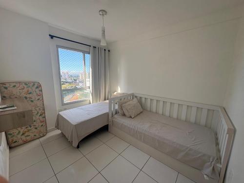 a small bedroom with two beds and a window at Apartment in Ponta Negra in Manaus