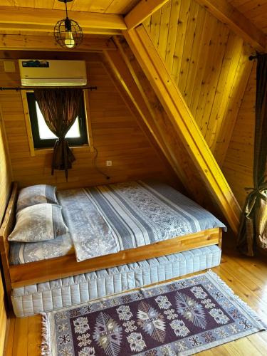 a bed in the attic of a log cabin at Vikendica Mia in Šipovo