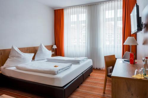 a hotel room with a bed and a desk at Gasthaus zur Krone in Weingarten (Karlsruhe)