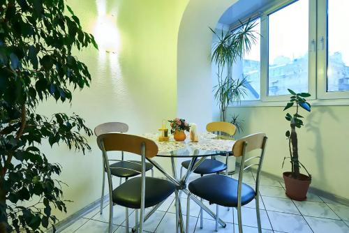 a table and chairs in a room with plants at Home Hotel Apartments on Kontraktova Ploshcha in Kyiv