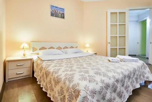 a bedroom with a large bed and two night stands at Home Hotel Apartments on Kontraktova Ploshcha in Kyiv