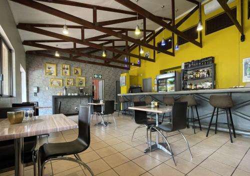 a restaurant with tables and chairs and a bar at Travel Lodge in Middelburg
