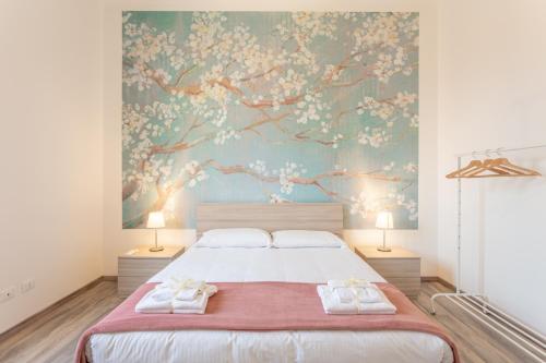 a bedroom with a large bed with two towels at Verdi 185 by Pleiades Home in Livorno
