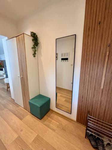 a mirror and a green ottoman in a room at Apartman Lukas in Županja
