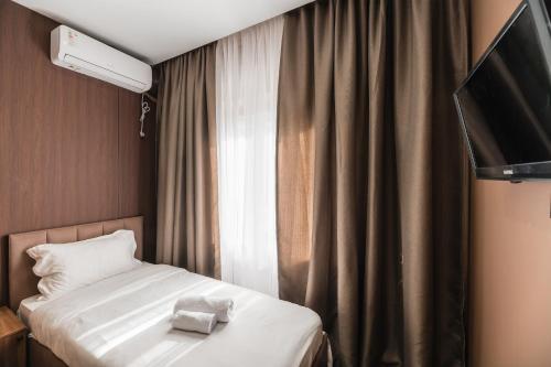 a hotel room with a bed and a television at MIRAFI Hotel in Almaty