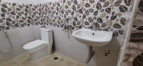 a bathroom with a toilet and a sink at Carmel Stay in Madurai