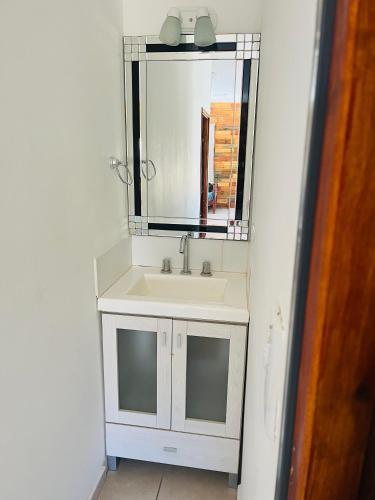 a bathroom with a white sink and a mirror at Cina Cina, casita in Zonda
