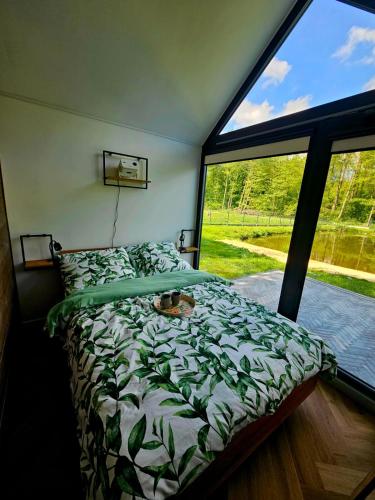 a bedroom with a bed and a large window at STAW się tu in Młyny