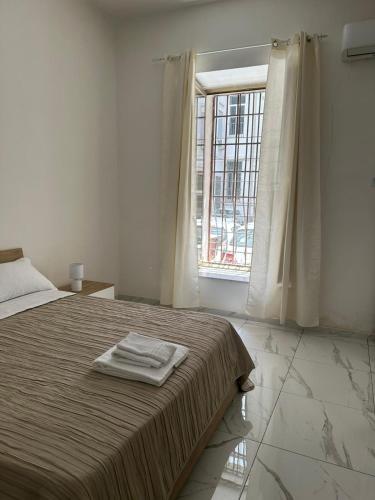 a white bedroom with a bed with a window at Binario104 in Naples