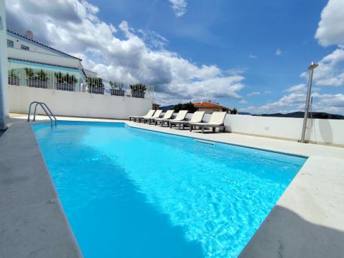 a swimming pool on the roof of a building at Villetta Borgo Bianco 1 con piscina in condivisione in Budoni