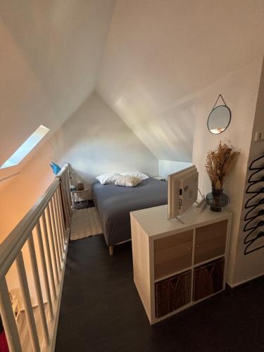 a small bedroom with a bed and a staircase at Beau duplex coeur historique et plages in Dives-sur-Mer