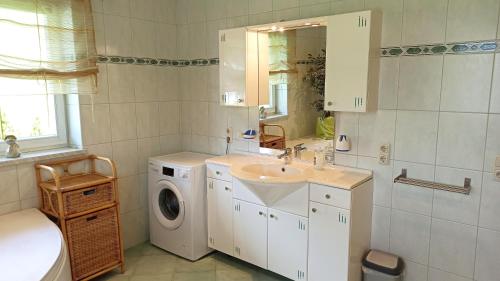 a bathroom with a sink and a washing machine at Villa Rupi in Sankt Ulrich am Pillersee