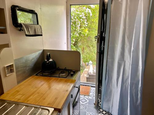 a kitchen with a stove in a tiny house at Solar Powered Hideaway converted horse box in Fishbourne
