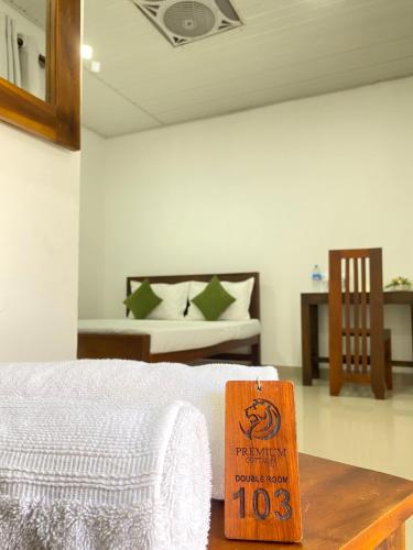 a room with a bed with a wooden sign on a table at Premium Cottages B&B in Kurunegala