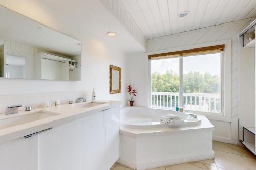 a white bathroom with two sinks and a large window at CJ295FLR Hawkins Lookout in Cudjoe Key