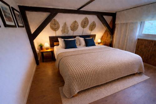 a bedroom with a large bed with blue pillows at 4Rest&Fun Krušné hory in Klíny