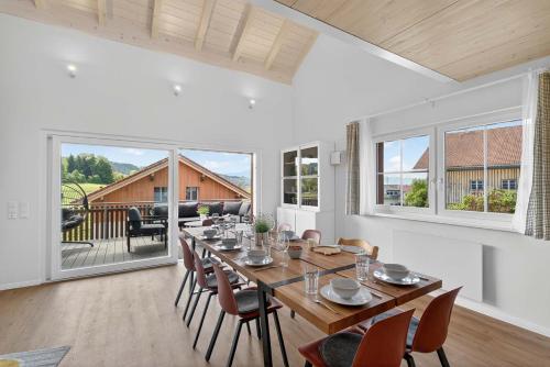 a dining room with a long table and chairs at FeWo Nägeleried - Große Galerie-Wohnung mit Balkon, Heimkino, Garten in Sulzberg