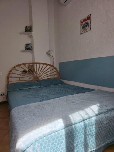 a bedroom with a large bed with a blue blanket at Chez Anna et Mat in Sérignan