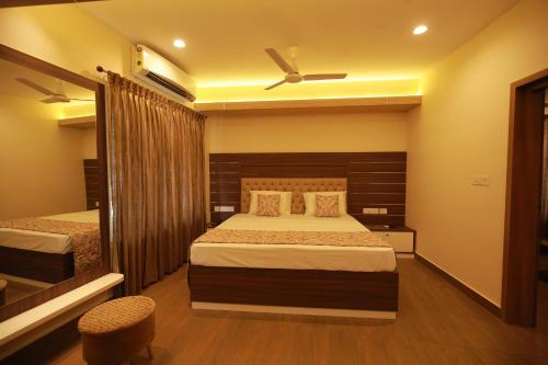 a bedroom with two beds and a ceiling fan at Fathima Residency in Pattanapuram