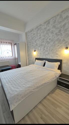 a bedroom with a large white bed with a large headboard at Coquette in Petrila