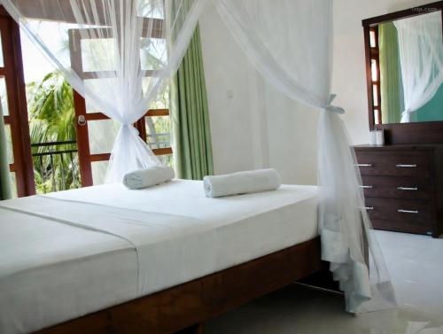 a bedroom with a bed and a window at Villa Estuary in Bentota