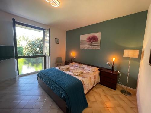 a bedroom with a bed and a large window at Garda MarANDGi Home Salo' in Salò