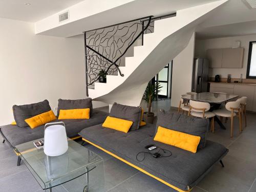a living room with a couch and a staircase at La pointe au sel in Aigues-Mortes