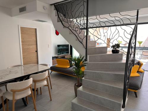 a staircase in a living room with a table and chairs at La pointe au sel in Aigues-Mortes