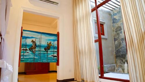 a hallway with a painting of horses on the wall at Villa Estuary in Bentota