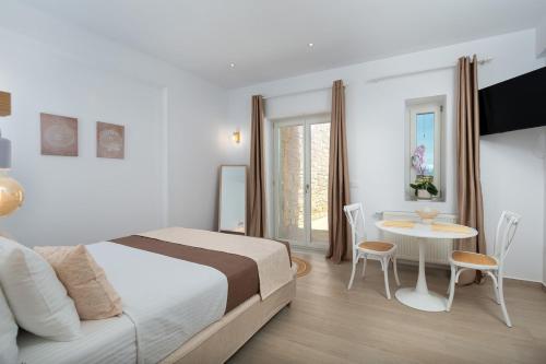 a bedroom with a bed and a table and chairs at Sunshine Alkyoni Suite in Isterni