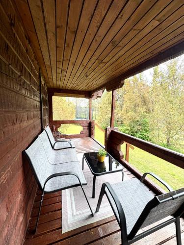 two chairs and a table on a wooden deck at Männiliiva Holiday Home with Sauna in Hiiumaa