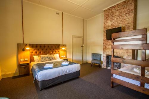 a hotel room with a bed and a chair at Pretoria Hotel in Mannum