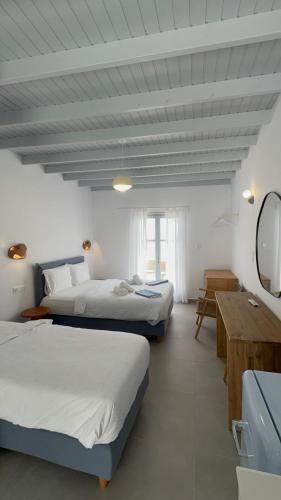 a hotel room with two beds and a mirror at Nikolas Rooms in Loutro