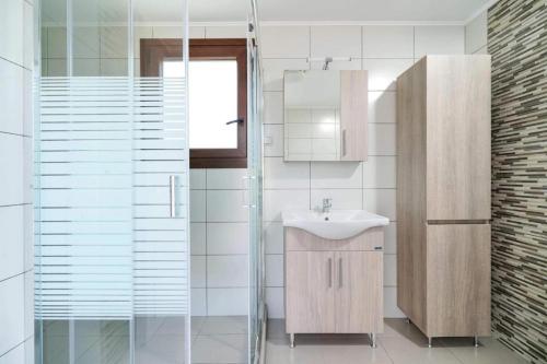 a bathroom with a sink and a glass shower at Apanemia in Kallirákhi