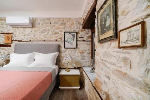 a bedroom with a bed and a stone wall at Apanemia in Kallirákhi
