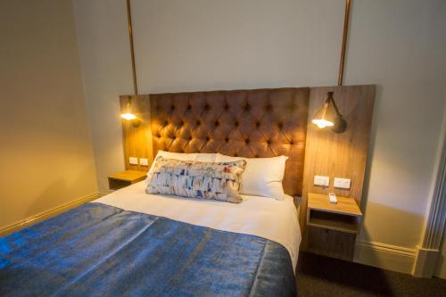 a bedroom with a large bed with a wooden headboard at Pretoria Hotel in Mannum
